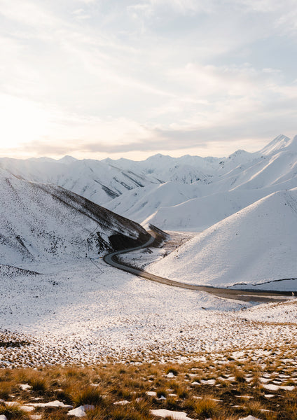 Snow covered Lindis Pass with winding road, Central Otago, New Zealand